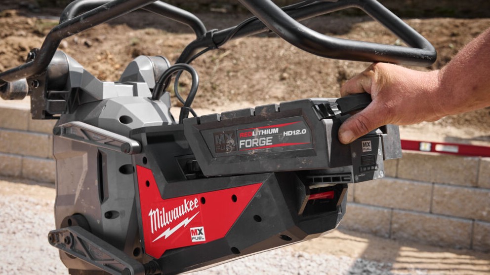 Batterie MX FUEL FORGE tenue par sa poignée sur le logement de la pilonneuse Milwaukee.